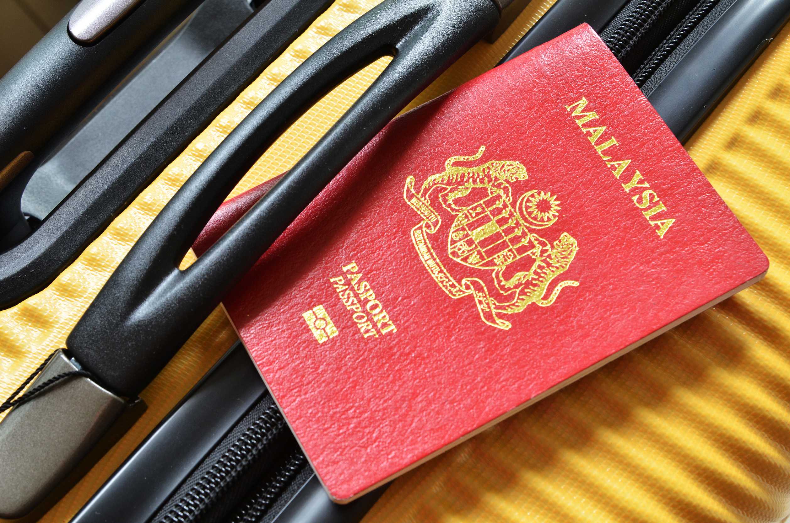 Malaysia Passport On A Yellow Suitcase Travel
